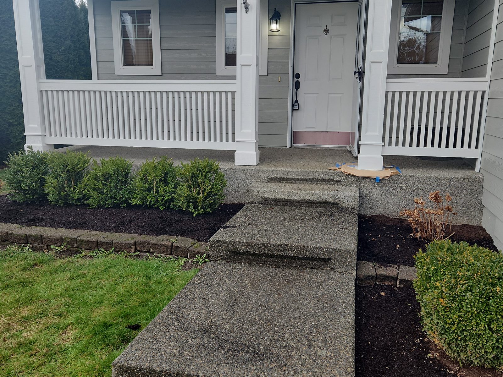 Completed front porch with new columns and white railing